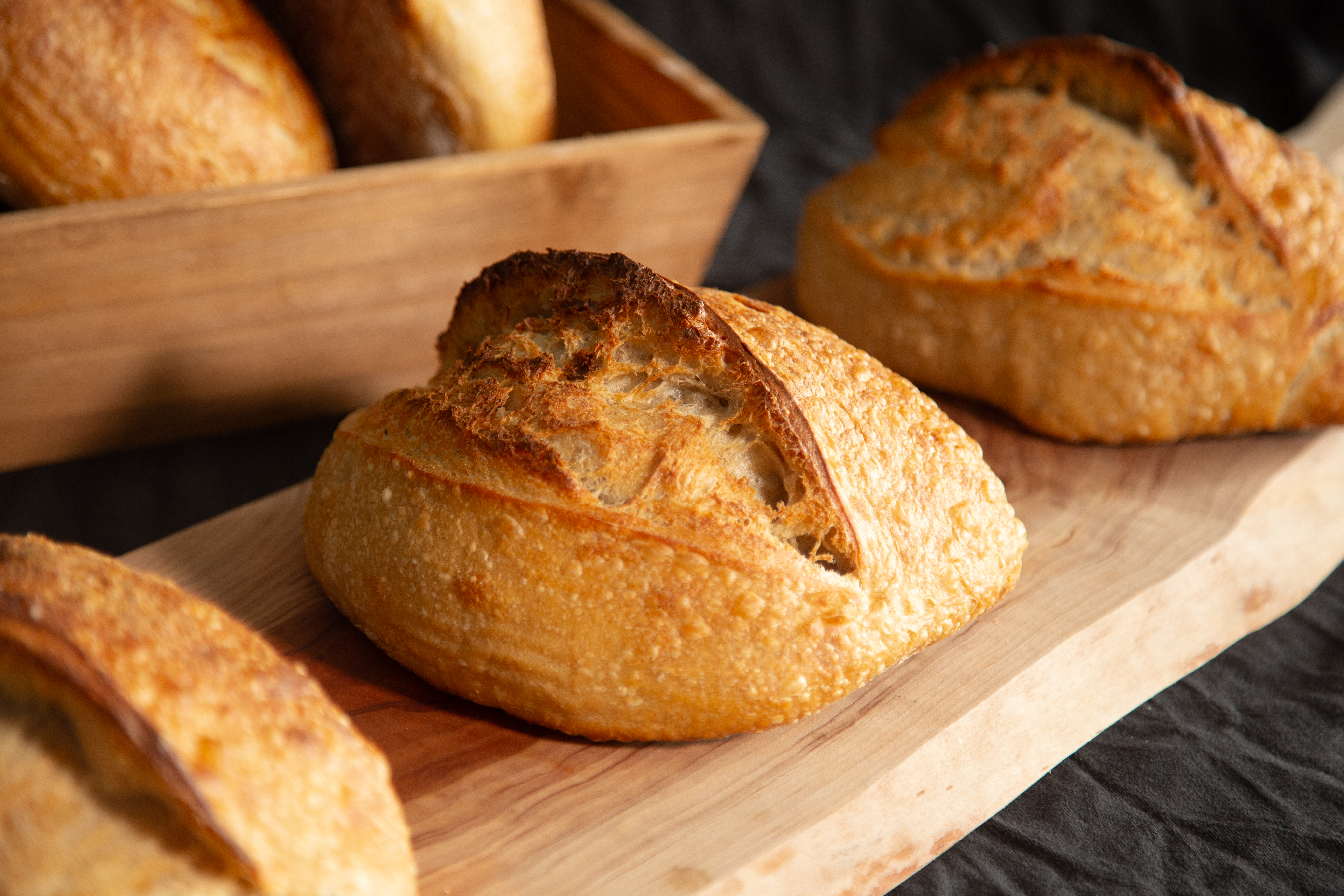 Artisan sourdough loaves on wooden cutting board